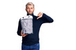 © Krakenimages.com - Young handsome blond man holding paper bin with crumpled papers with angry face, negative sign showing dislike with thumbs down, rejection concept