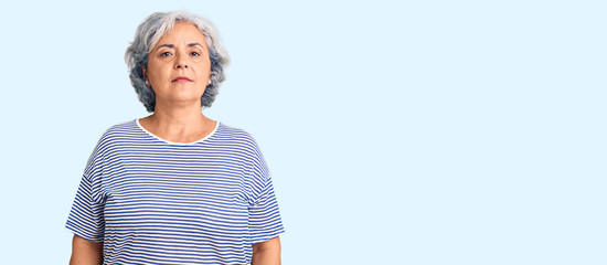 Wall Mural - Senior woman with gray hair wearing casual striped clothes relaxed with serious expression on face. simple and natural looking at the camera.