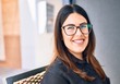 © Krakenimages.com - Young beautiful brunette woman wearing glasses smiling happy and confident. Sitting with smile on face at restaurant
