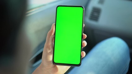 Close up of a woman's hand holding a mobile telephone with a vertical green screen in car chroma key smartphone technology cell phone street touch message display hand