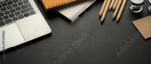 Fotomural Workspace with laptop, stationery, supplies and copy space on black leather tabl