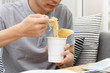 Work from home,Businessman working remotely from home. Using computer and eating cup noodle. Distance learning online education and work