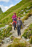 Fototapeta Las - Family hiking into the mountains