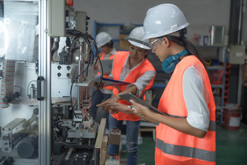 woman working engineering or technical inspection the system  of machinery to ensure working in order by checklist part and quality control, wrkplace with teamwork together