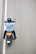 © DragonImages - Man in denim jacket riding on motorcycle on highway, view from above