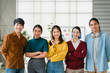 © tirachard - Group of Asia young creative people in smart casual wear smiling and arms crossed in creative office workplace. Diverse Asian male and female stand together at startup. Coworker teamwork concept.