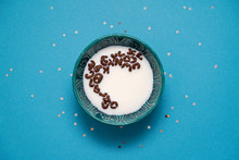 Blue Background With Stars. Bowl With Milk And Alphabet Cocoa Cereals