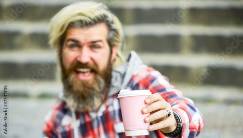 man with a cup of coffee outdoors. selective focus. Handsome calm bearded man outdoors with a cup. Man drinking hot coffee. tourist relaxing on stairs drink tea or coffee. Coffee on the go