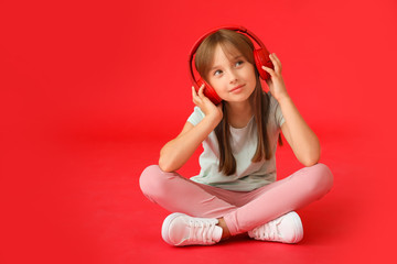 Canvas Print - Little girl listening to music on color background