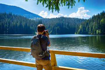 Photographer takes a picture of a beautiful mountain lake. Lake Synevyr. Ukraine. Carpathians. Natural nature. Hobby. Job. T