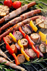 Wall Mural - Grilled food, skewers and sausages wrapped in bacon  with aromatic herbs on cast iron grill top view