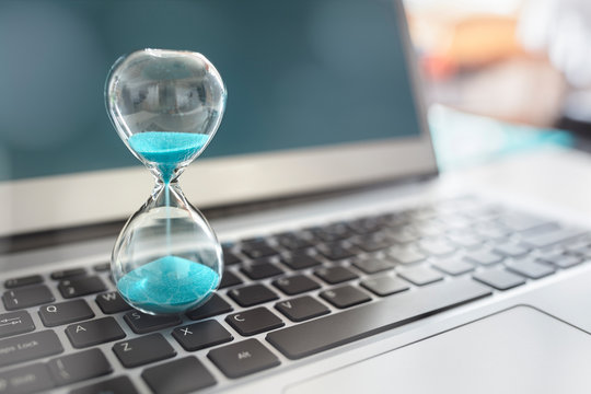 Hourglass on laptop computer concept for time management