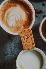 Cookie placed on two espresso cups. Freshly made espresso
