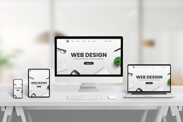 Creative web design studio desk with different devices and responsive web page concept on device screens. Modern flat web site design concept