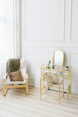 Boudoir table and chair with a blanket and pillow near the window. Interior details of bedrooms for girls and women