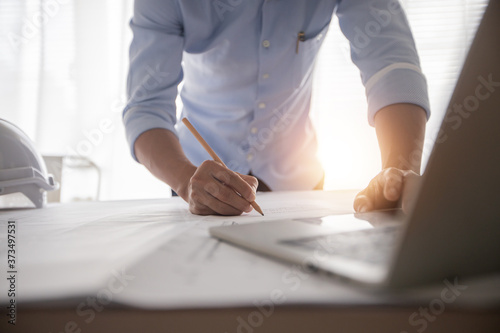 Obraz Dibond Architect working in office with blueprints,engineer thinking and planning inspection in workplace for architectural plan,sketching a construction project,Business construction concept.
