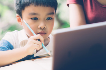 Wall Mural - Son using digital tablet computer for study and learn to internet online with mother together, education from home, family recreation, mom teach boy and homework with technology, lifestyle concept.