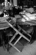 Holzstuhl und runde Bistrotische in einem geschlossenen Biergarten im Sommer bei Sonnenschein im Westend von Frankfurt am Main in Hessen, fotografiert in klassischem Schwarzweiß