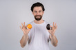 © Ivan - Man with long beard shows avocado and orange. Fruit and healthy organic food. Dieting and fitness.