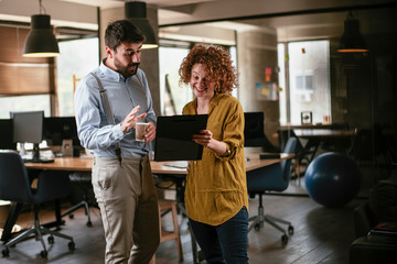 Businesswoman and businessman discussing work in office. Two friends in working together..