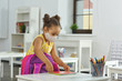 © ShunTerra - A child in medical mask and a yellow dress stands in the classroom and prepares for a lesson