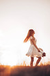 © stivog - Ginger girl running through the field, holding a summer hat. Copy space