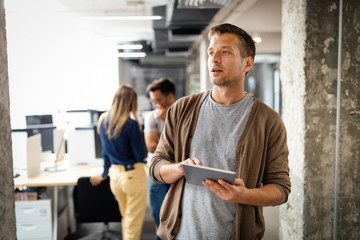 Young man using technology, digital tablet in corporate business office