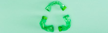 Panoramic Shot Of Recycle Sign From Crumpled Plastic Bottles On Green Background, Ecology Concept