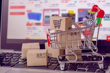 Shopping online. cardboard box with a shopping cart logo in a trolley on laptop keyboard. Shopping service on The online web. offers home delivery.