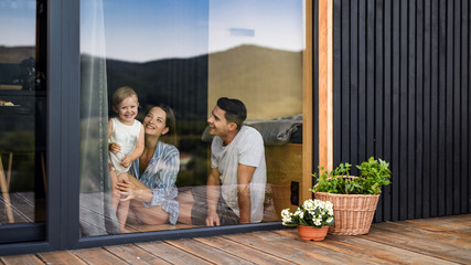 young family with small daughter indoors, weekend away in container house in countryside.