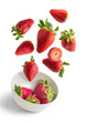 © Cavan Images - Strawberries flying in white bowl isolated from the background