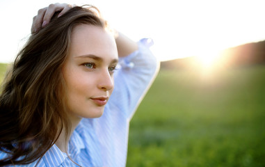  Portrait of young teenager girl outdoors in nature at sunset.