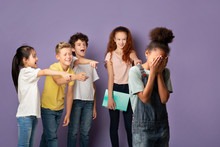 Group Of Schoolkids Bullying Their Crying African American Classmate Over Lilac Background