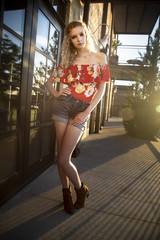 Sticker - Beautiful blonde female wearing an off shoulder blouse, shorts and boots