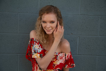 Poster - Beautiful smiling blonde female wearing a red off shoulder blouse