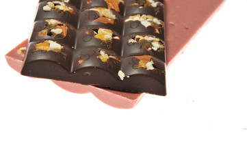 Two bars of milk and pink chocolate with raisins and dried apricots close-up