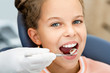 © Peakstock - Little smiling girl, teeth check-up. Tooth exam using dental mirror close-up. Child's teeth treatment