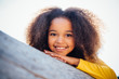 © Clara Lu - portrait of a young African American girl resting on log