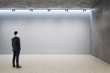 Poster - Businessman standing in exhibition hall interior