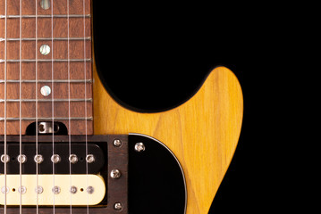 front part of the body of an electric guitar on black background