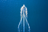 Drone view of a boat sailing. Top view of a white boat sailing to the blue sea. Motor boat in the sea. Travel - image.