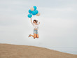 © Irina Magrelo - Young woman jumping with blue and white helium balloons