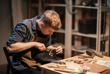 A Young Man Is Engaged In The Family Craft Of Making Leather Shoes In A Workshop