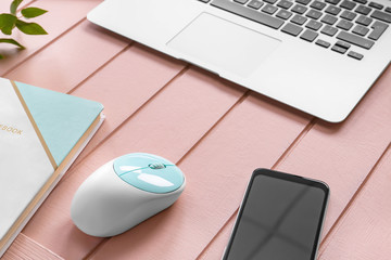 Modern PC mouse, smartphone and laptop on table