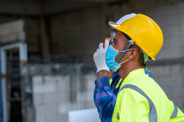 Poster - Engineer wearing protective mask to Protect Against Covid-19 at construction site.