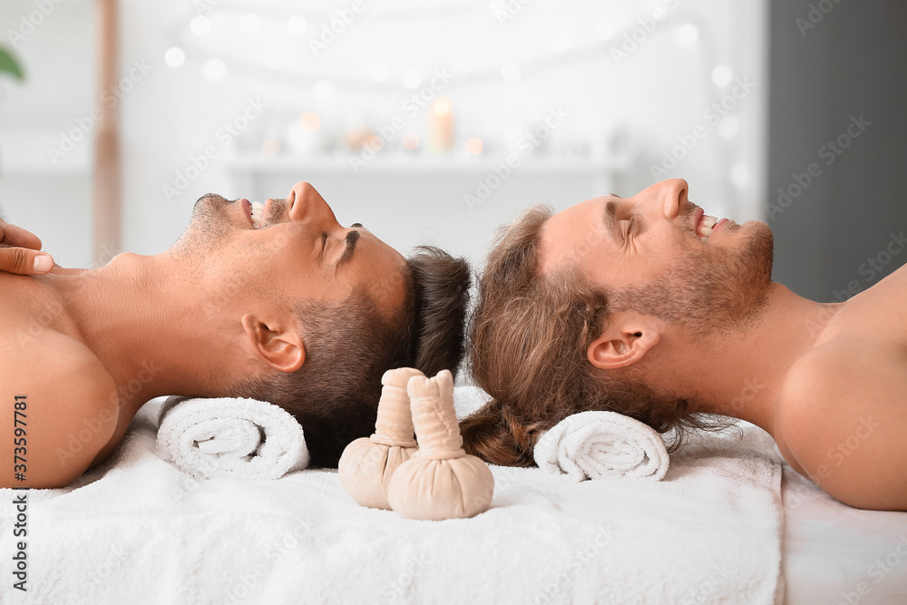 Happy gay couple relaxing in spa salon