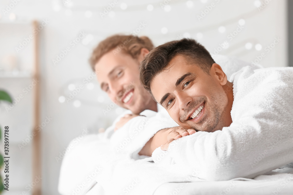 Happy gay couple relaxing in spa salon