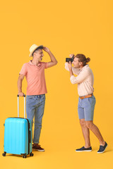 Wall Mural - Couple of gay tourists on color background