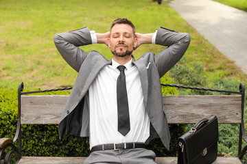 Poster - Handsome businessman relaxing in park