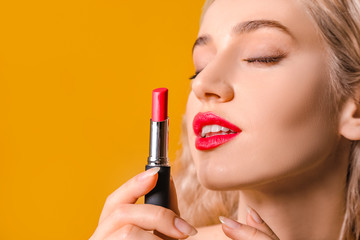 Wall Mural - Beautiful young woman with bright lipstick on color background